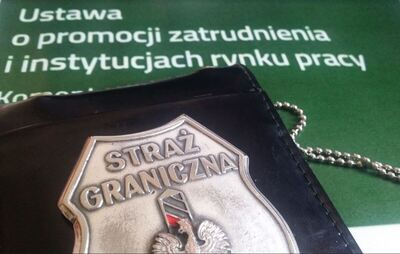 Na okładce ustawy o promocji zatrudnienia i instytucjach rynku pracy leży metalowa odznaka funkcjonariusza straży granicznej.