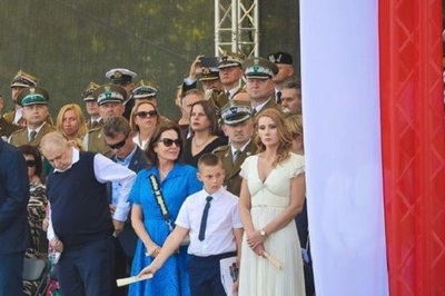 Uczestnicy uroczystości w Warszawie stoją na trybunie, oglądają defiladę
