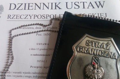 Odznaka Straży Granicznej położona na papierowej wersji Ustawy o cudzoziemcach