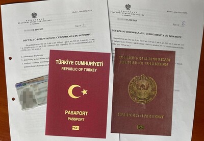 Na dwóch decyzjach o zobowiązaniu do powrotu leżą polska karta pobytu, paszport turecki i paszport obywatela uzbekistanu