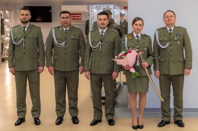 pamiątkowe zdjęcie emerytki z komendantem placówki sg w  krakowie balicach oraz kolegami funkcjonariuszami z placówki