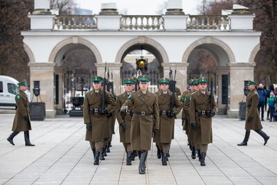 funkcjonariusze straży granicznej dokonują uroczystej zmiany warty honorowej przed grobem nieznanego żołnierza w warszawie. po zmianie warty odchodzą od pomnika idąc w szyku.