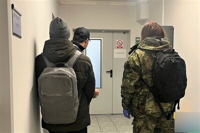 W korytarzu placówki sg w krakowie stoją dwaj zatrzymani indonezyjczycy. Za nimi funkcjonariuszka sg
