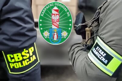 zbliżenie na ramiona funkcjonariusza CBŚP, z odblaskowymi opaskami. Po lewej stronie napis CBŚP Policja, po prawej Straż Graniczna Po środku zdjęcia logo KaOSG