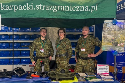 dwóch funkcjonariuszy i funkcjonariuszka sg stoją na stoisku przygotowanym na targach edukacyjnych przez zakopiańską placówkę