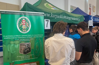 uczniowie stoją przy stoisku karpackiego oddziału straży granicznej podczas targów edukacyjnych