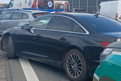 na zdjęciu widoczne jest zdarzenie drogowe. wypadek ma miejsce na autostradzie. na pierwszym planie widoczny pojazd służbowy straży granicznej oraz pojazd biorący udział w zdarzeniu. w tle widoczne są samochody karetek pogotowia ratunkowego.