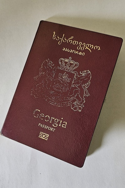 Na zdjęcie widnieje dokument paszportowy koloru bordowego ze złotymi napisami