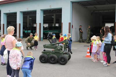dzieci patrzą na robota pirotechnicznego który jedzie na kołach -