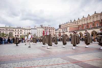 Orkiestra reprezentacyjna straży granicznej podczas pokazy musztry paradnej na rynku w Krakowie, w tle ludzie podziwiający występ