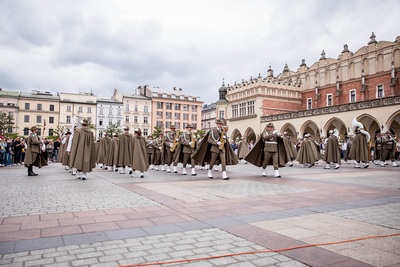 Orkiestra reprezentacyjna straży granicznej podczas pokazy musztry paradnej na rynku w Krakowie, w tle ludzie podziwiający występ