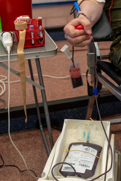 Zaciśnięta dłoń ściskająca czerwona piłkę podczas pobierani krwi
