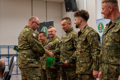 Funkcjonariusz wręcza innym funkcjonariuszom wyróżnienia w formie dyplomu