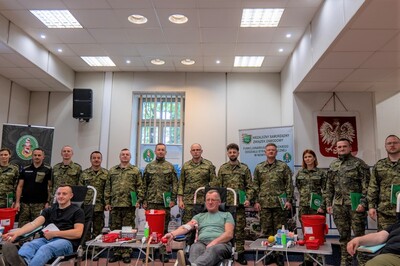 zdjecie grupowe wyróżnionych funkcjonariuszy podczas oddawania krwi przez 3 osoby