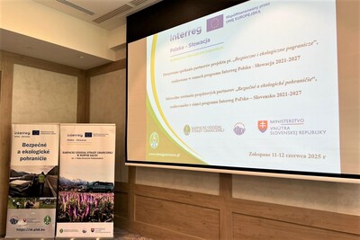 Wyświetlanie prezentacji multimedialnej na ekranie projektora na temat bezpieczne i ekologiczne pogranicze w lewym dolnym rogu rollapy policji słowackiej oraz straży granicznej