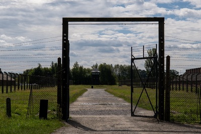 Brama metalowa do Auschwitz II Birkenau. w tle wieżyczki wartownicze i baraki