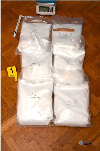 Na zdjęciu widać poukładane w dwóch rzędach woreczki z białą zawartością na drewnianej podłodze.