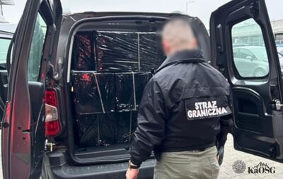 Zdjęcie dowodowe przedstawiające dwie otwarte, duże walizki podróżne, wewnątrz których znajdują się przezroczyste, próżniowo zapakowane pakiety z suszem roślinnym, prawdopodobnie narkotykami, oraz linijka pomiarowa.