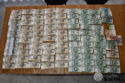 na stole leży mnóstwo pieniędzy w banknotach o różnych nominałach, większość to polska waluta.