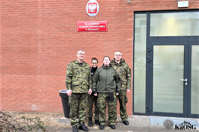 kapelan sg stoi z trzema funkcjonariuszami sg przed wejściem do placówki sg w słubicach