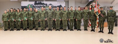 Pamiątkowe zdjęcie grupowe wszystkich uczestników uroczystości na tle ścianki z napisem "Karpacki Oddział Straży Granicznej". Wszyscy są w mundurach polowych.