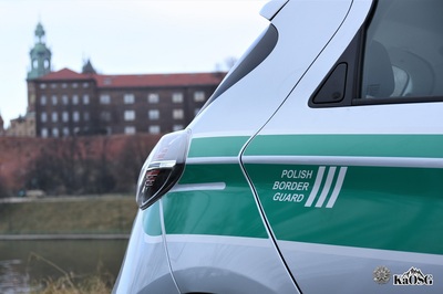 ujęcie przez tył pojazdu służbowego sg z napisem polish border guard, w tle zabudowania zamku królewskiego na wawelu