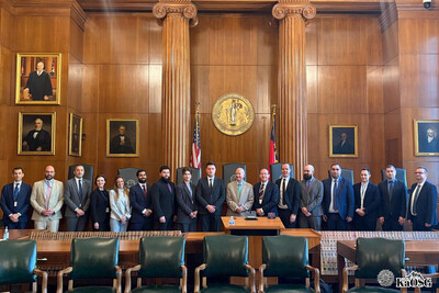 kilkanaście osób w garniturach stoi w sali plenarnej. w tle dwie kolumny drewniane, obrazy elitarnych przedstawicieli usa