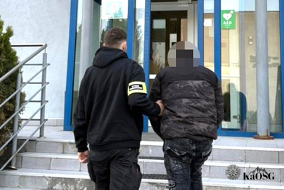 Na zdjęciu widać dwie osoby, które wchodzą po schodach do budynku.