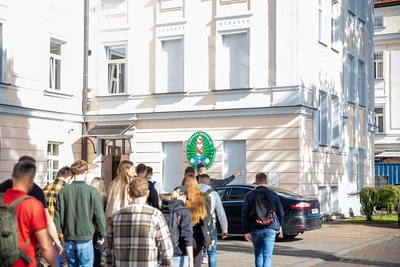 Nowo przyjęci funkcjonariusze zmierzają do budynku Komendy KaOSG. W tle logo Karpackiego Oddziału Straży Granicznej