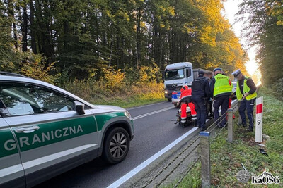 Droga na której doszło do zdarzenia drogowego. widać przybyłe na miejsce służby - policję i zespół ratownictwa medycznego. na dole po lewej samochód straży granicznej